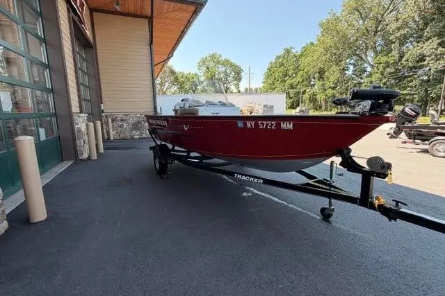 The Image of 2017 Tracker Pro Guide V-16 SC boat on trailer, parked outdoors near building. - 1