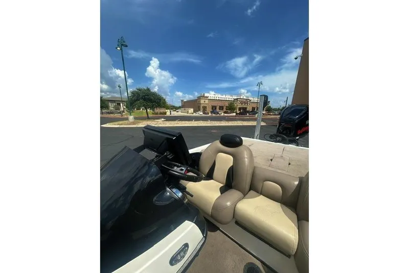 Slide: The Image of 2012 Skeeter 21i boat interior with beige seating under a clear blue sky. - 7