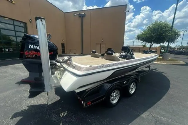 Slide: The Image of 2012 Skeeter 21i boat with Yamaha motor, parked outdoors under a blue sky. - 3