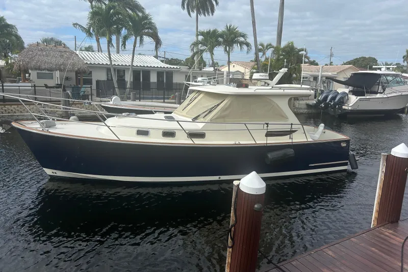 Slide: The Image of 2007 Legacy EXPRESS CRUISER docked by palm trees and waterfront homes. - 1