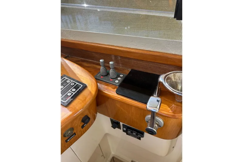 Slide: The Image of 2007 Legacy EXPRESS CRUISER helm controls with wooden finish and navigation equipment. - 15