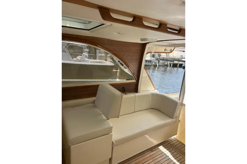Slide: The Image of Interior of 2007 Legacy EXPRESS CRUISER with cream seating and wooden accents by the water. - 4
