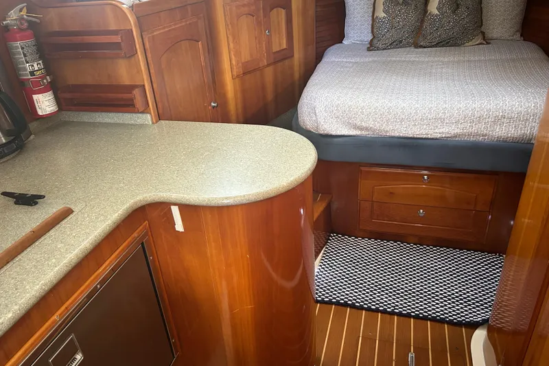 Slide: The Image of Interior of 2007 Legacy EXPRESS CRUISER with wood cabinetry and cozy sleeping area. - 25