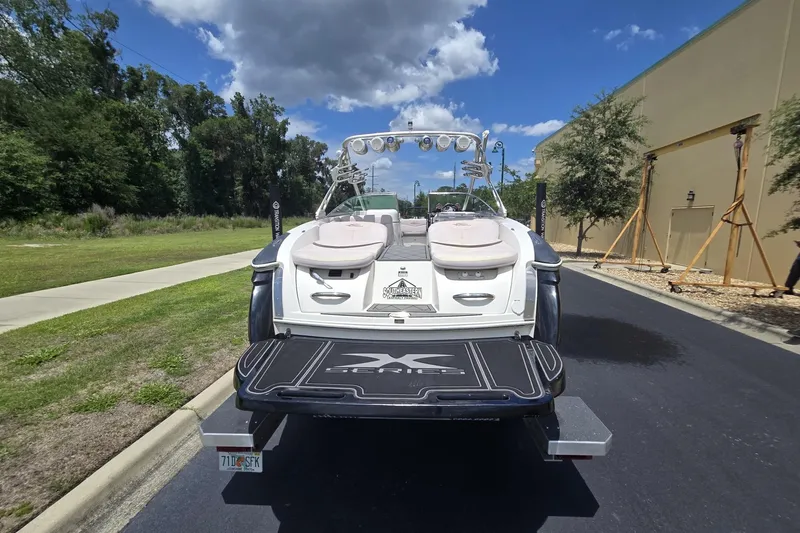 Slide: The Image of 2006 MasterCraft X-80 boat on trailer, parked outdoors under a blue sky. - 1