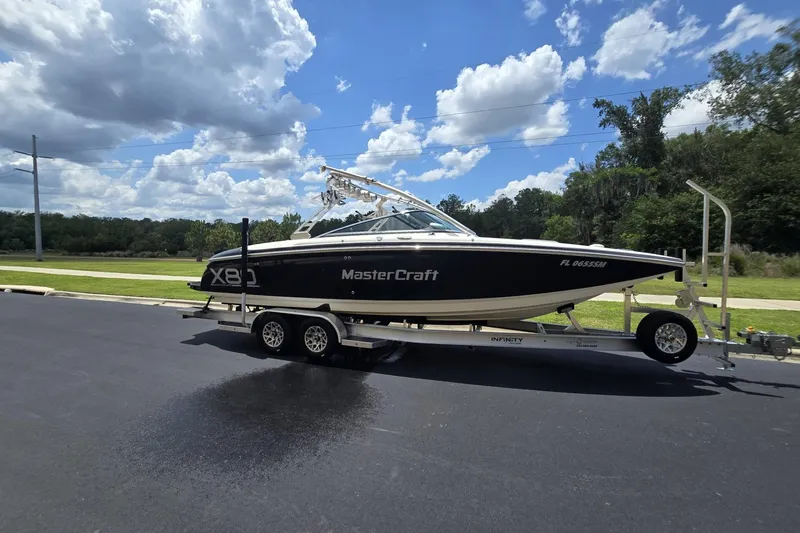 Slide: The Image of 2006 MasterCraft X-80 boat on trailer under a partly cloudy sky. - 7