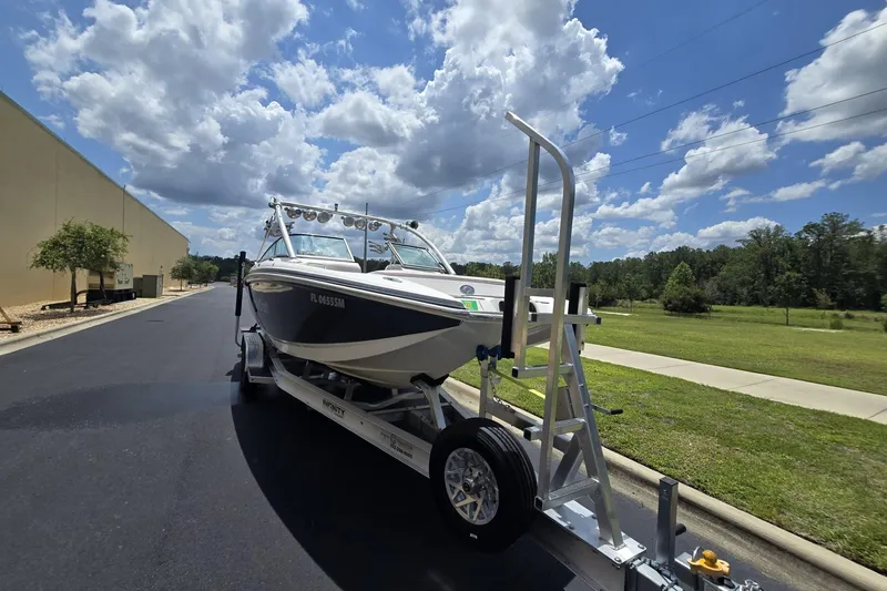 Slide: The Image of 2006 MasterCraft X-80 boat on trailer under a partly cloudy sky. - 6