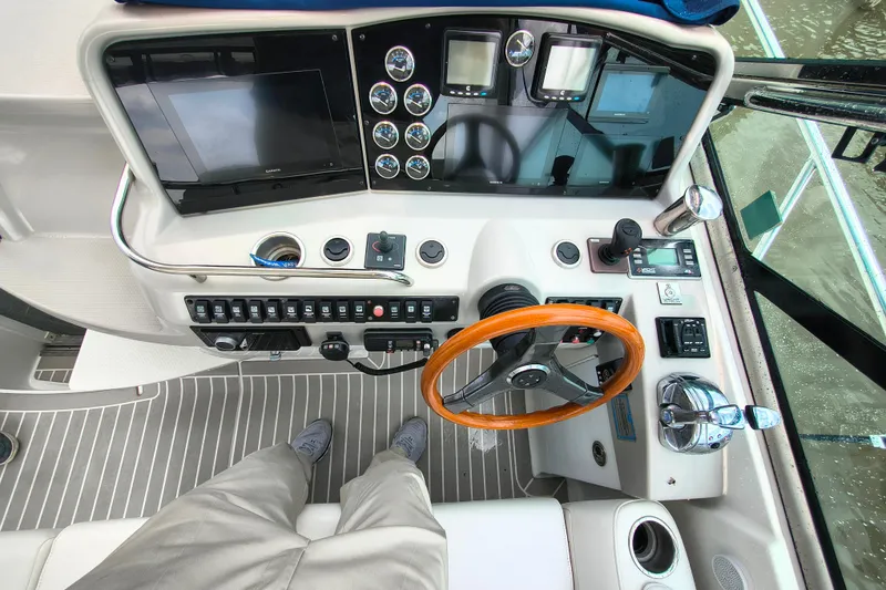 Slide: The Image of Cockpit view of a 2005 Formula 48 Yacht with modern navigation controls and wooden steering wheel. - 11