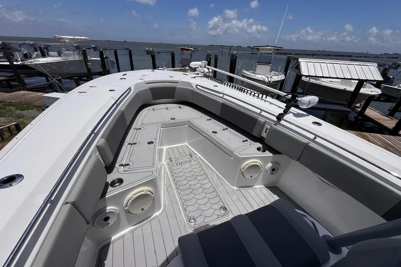Slide: The Image of 2020 Cape Horn 32XS boat docked, showcasing spacious deck and seating area under clear skies. - 15