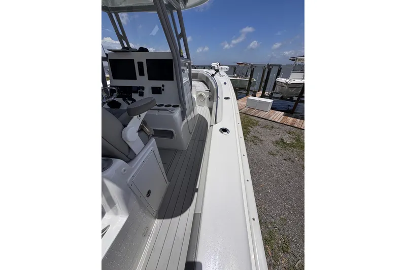 Slide: The Image of 2020 Cape Horn 32XS boat interior with helm, docked under clear sky. - 3