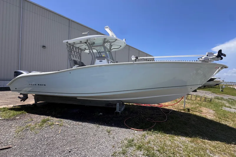 The Image of 2020 Cape Horn 32XS boat displayed outdoors near a warehouse. - 1
