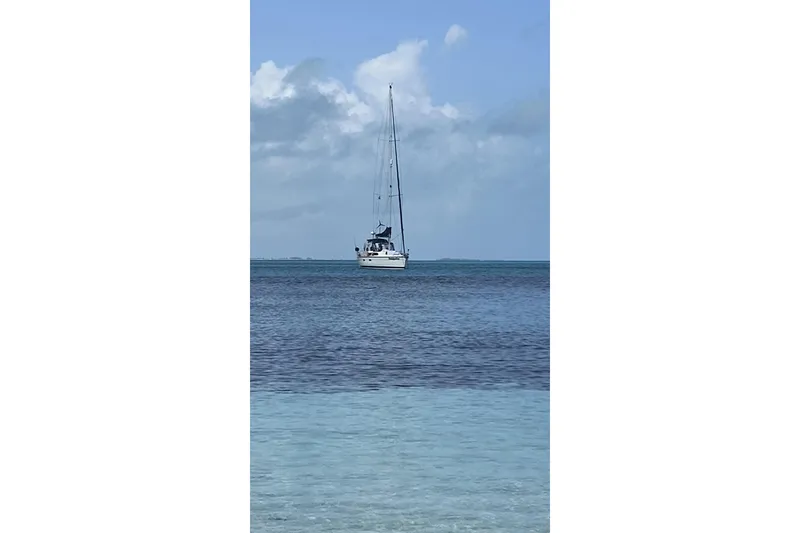 Slide: The Image of Sailboat "Bass Hunter Passage" 1994 on calm ocean waters under a cloudy sky. - 3
