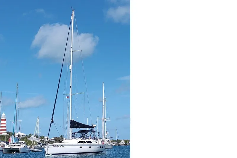 Slide: The Image of Sailboats anchored in a harbor, featuring a 1994 Bass Hunter Passage. - 6