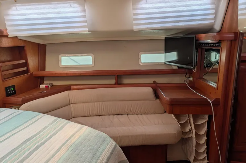 Slide: The Image of 1994 Bass Hunter Passage yacht interior with cozy seating, TV, and wooden accents. - 12