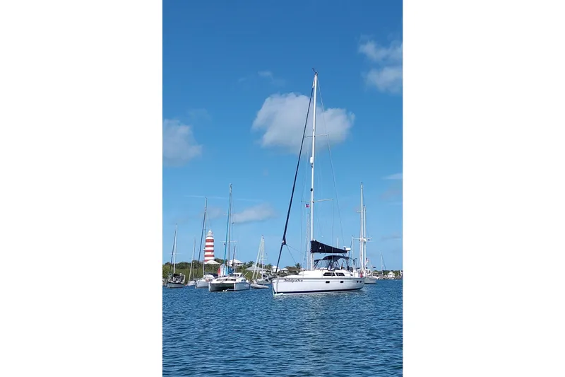 Slide: The Image of Sailboats anchored in a harbor, featuring a 1994 Bass Hunter Passage. - 6