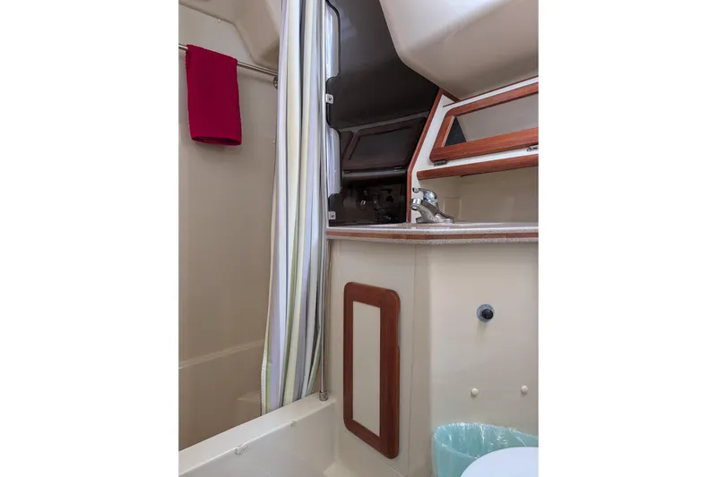 Slide: The Image of 1994 Bass Hunter Passage boat interior with sink, shower curtain, and red towel. - 13
