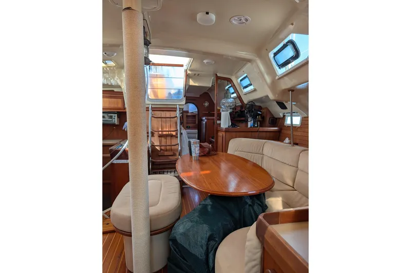 Slide: The Image of Interior of 1994 Bass Hunter Passage yacht with wooden table and beige seating. - 10