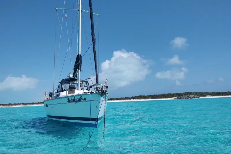 Slide: The Image of Sailboat "IndulgenSea" on turquoise waters, Bass Hunter Passage 1994, clear sky, sandy beach backdrop. - 8
