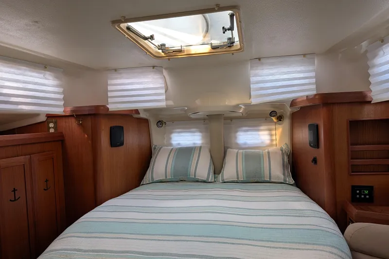 Slide: The Image of Cozy cabin interior of a 1994 Bass Hunter Passage boat with striped bedding and wooden accents. - 23