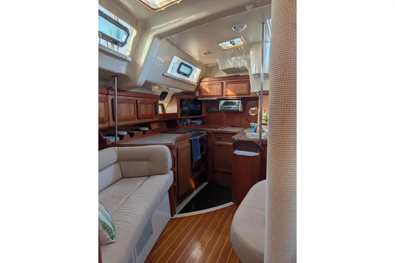 Slide: The Image of Interior of 1994 Bass Hunter Passage boat with cozy seating and wooden cabinetry. - 17