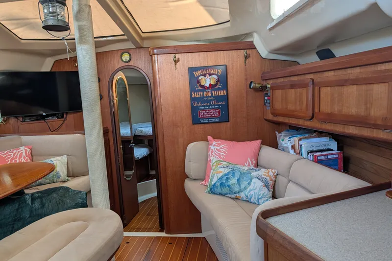 Slide: The Image of Cozy 1994 Bass Hunter Passage yacht interior with plush seating, nautical decor, and wooden cabinetry. - 16