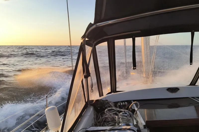 Slide: The Image of Sailing on a 1994 Bass Hunter Passage boat at sunset, waves splashing against the hull. - 4