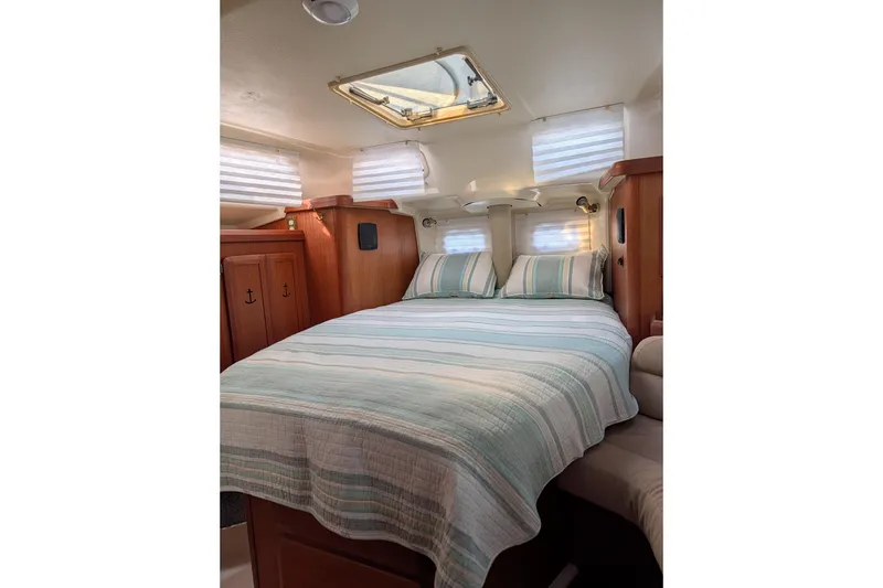 Slide: The Image of Cozy cabin interior of 1994 Bass Hunter Passage boat with striped bedding and wooden accents. - 22