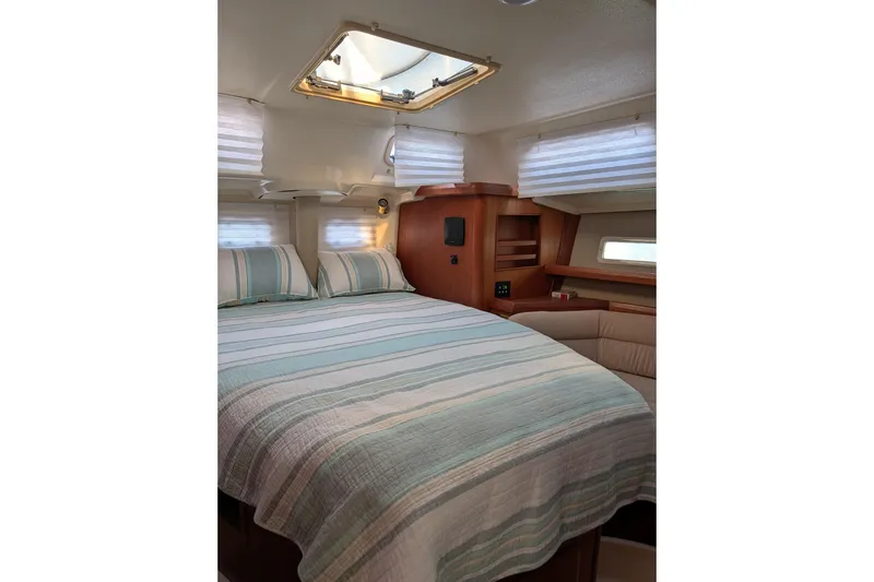 Slide: The Image of Cozy cabin interior of 1994 Bass Hunter Passage boat with striped bedding and wooden accents. - 11