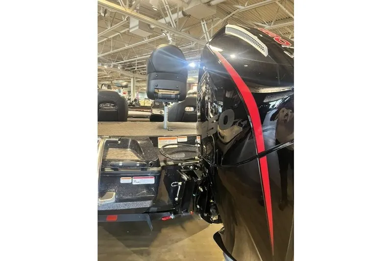 Slide: The Image of 2026 Nitra Boats Z20XL with sleek black and red design in showroom. - 3