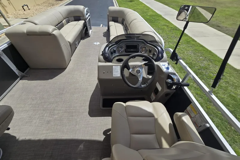Slide: The Image of 2021 Sun Tracker Party Barge 24 DLX interior with beige seating and steering console. - 9
