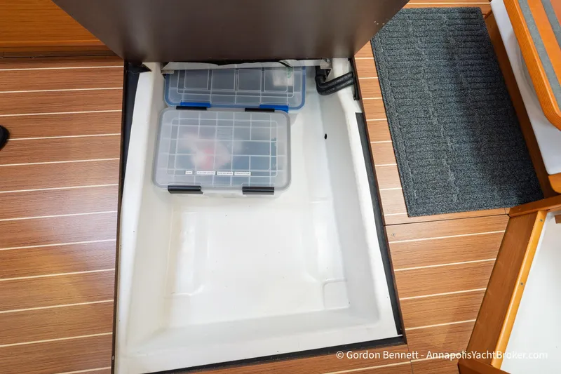 Slide: The Image of Storage compartment on Jeanneau Sun Odyssey 439 yacht, featuring organized plastic containers. - 63