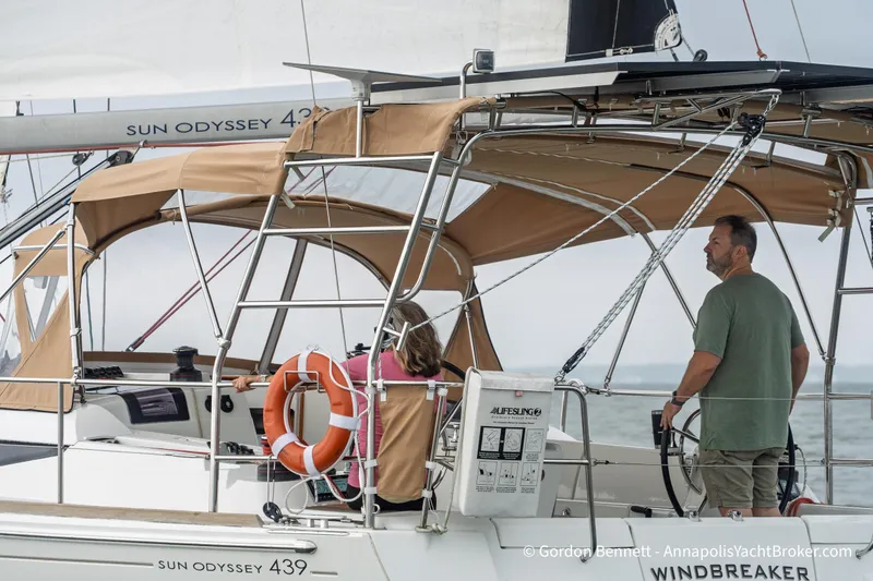 Slide: The Image of 2015 Jeanneau Sun Odyssey 439 sailboat with tan canopy, sailing on open water. - 7