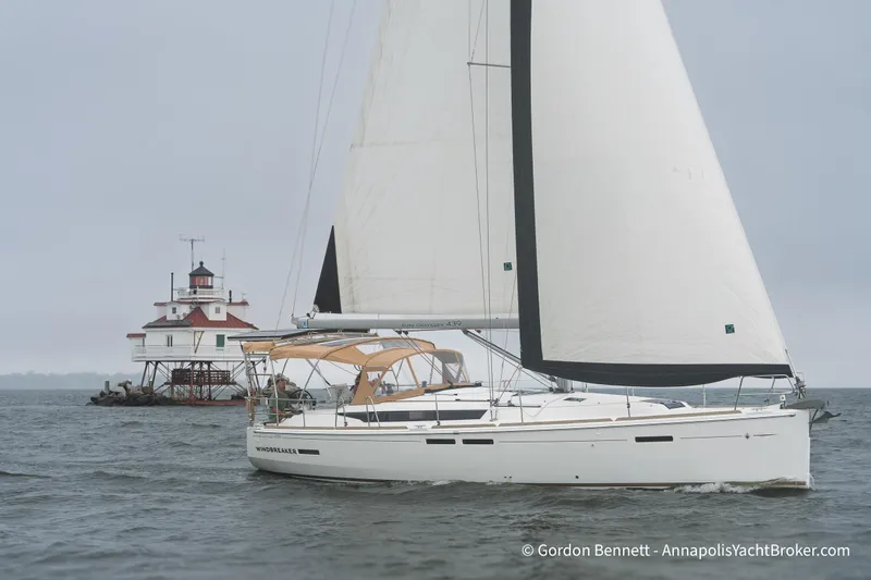 The Image of 2015 Jeanneau Sun Odyssey 439 sailing near a lighthouse on a cloudy day. - 0