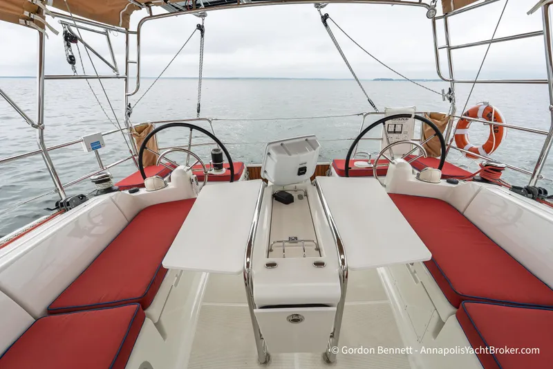Slide: The Image of Cockpit of 2015 Jeanneau Sun Odyssey 439 yacht with dual steering wheels and red seating. - 23