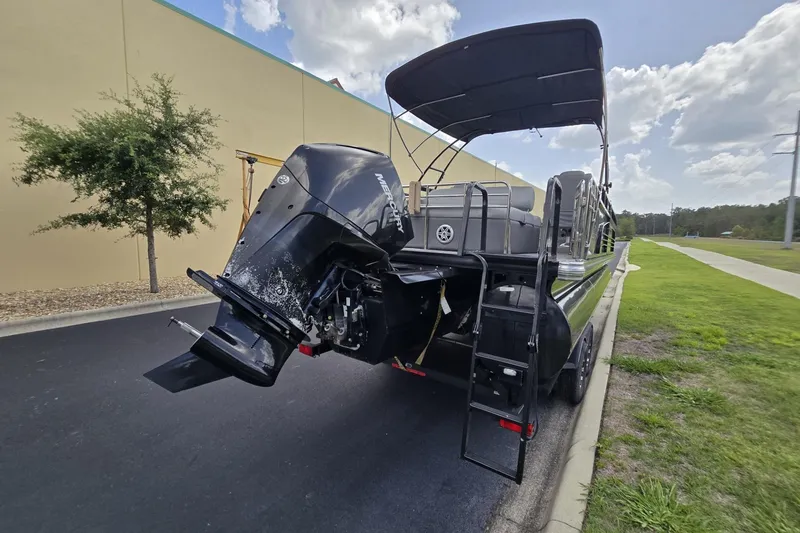Slide: The Image of 2019 Regency 230 LE3 Sport pontoon boat with Mercury outboard motor, parked outdoors. - 3