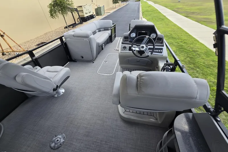 Slide: The Image of 2019 Regency 230 LE3 Sport pontoon boat interior with plush seating and modern helm. - 6