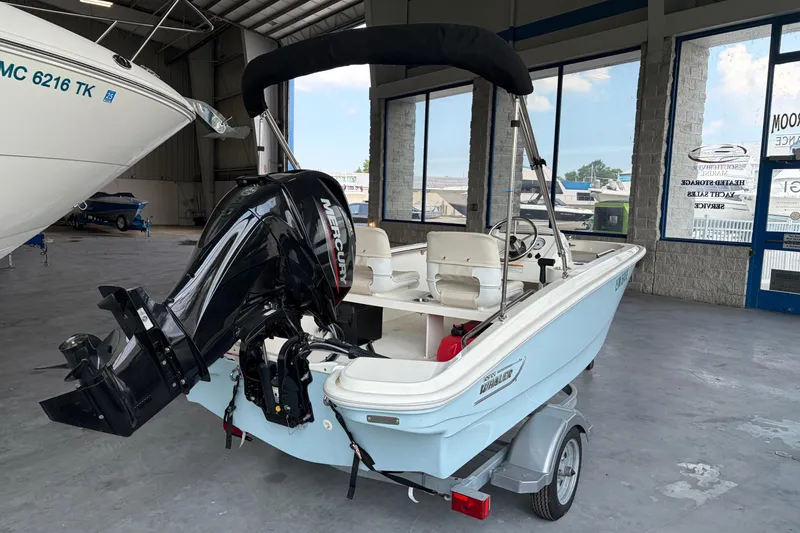 Slide: The Image of 2024 Boston Whaler 130 Super Sport boat with Mercury engine in showroom. - 23