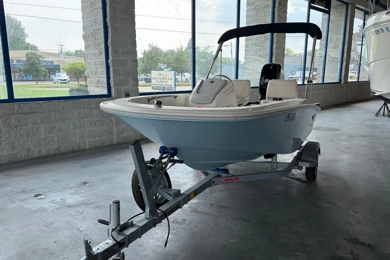 Slide: The Image of 2024 Boston Whaler 130 Super Sport boat on trailer in showroom. - 22