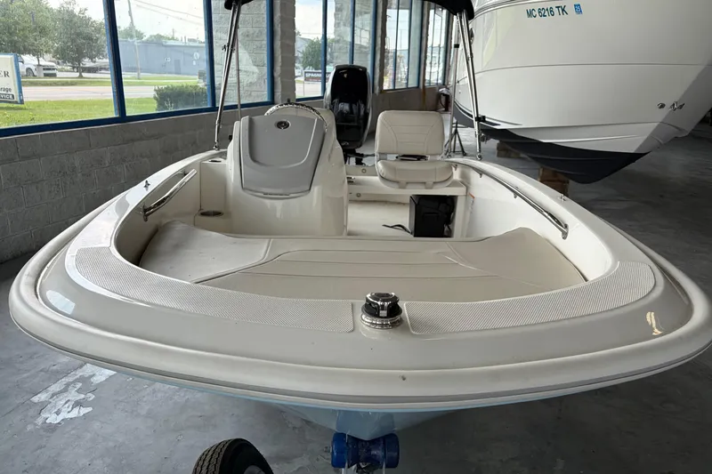 Slide: The Image of 2024 Boston Whaler 130 Super Sport boat in showroom, showcasing sleek design and seating. - 28