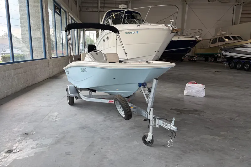 Slide: The Image of 2024 Boston Whaler 130 Super Sport boat on trailer in indoor showroom. - 24