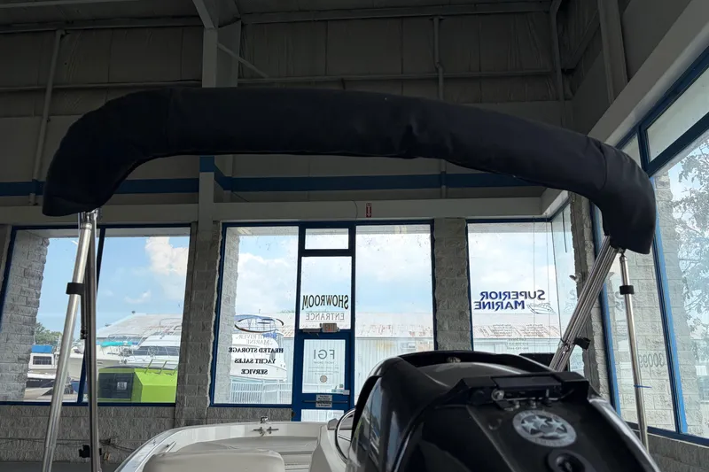 Slide: The Image of 2024 Boston Whaler 130 Super Sport boat with bimini top in showroom setting. - 19