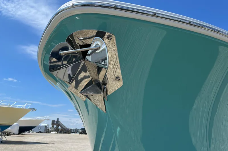 Slide: The Image of 2024 Sportsman Heritage 231 Center Console boat, close-up of bow with anchor, clear sky background. - 5