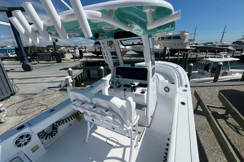 Slide: The Image of 2024 Sportsman Heritage 231 Center Console boat at marina, showcasing helm and seating area. - 7