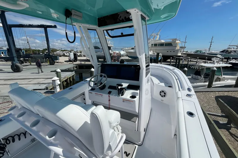 Slide: The Image of 2024 Sportsman Heritage 231 Center Console boat at marina, showcasing helm and seating area. - 8