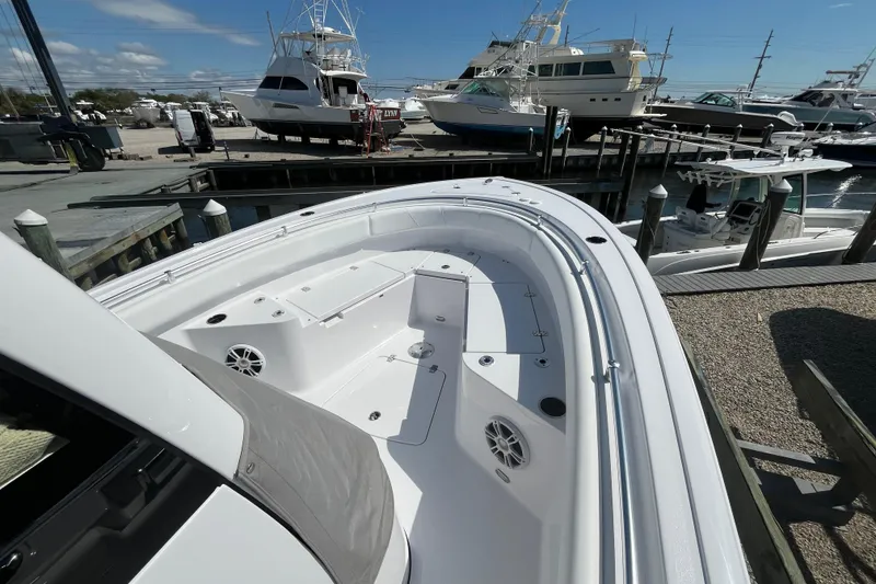 Slide: The Image of 2024 Sportsman Heritage 231 Center Console boat docked at a marina under clear skies. - 11