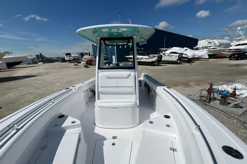 Slide: The Image of 2024 Sportsman Heritage 231 Center Console boat in a marina under a clear blue sky. - 12