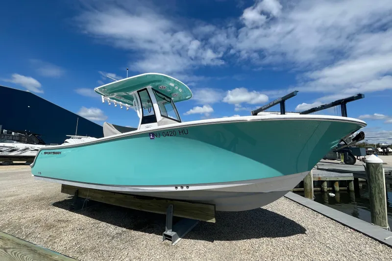 Slide: The Image of 2024 Sportsman Heritage 231 Center Console boat on display under a blue sky. - 15
