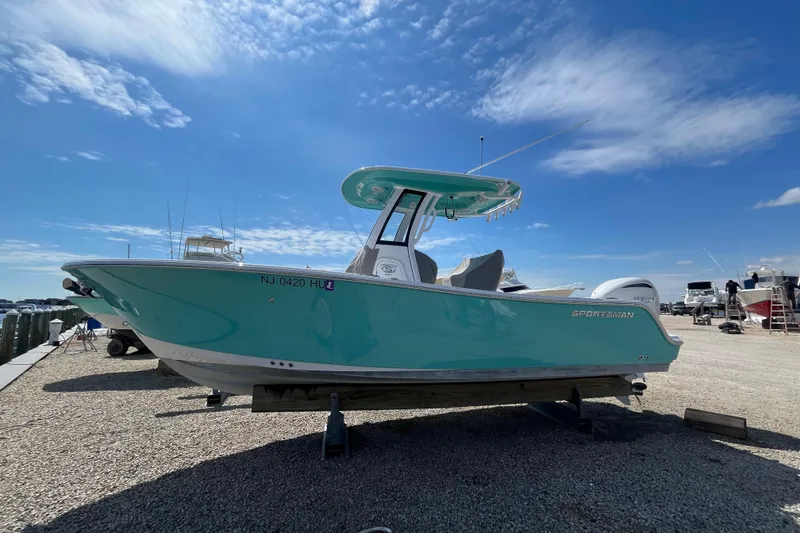 Slide: The Image of 2024 Sportsman Heritage 231 Center Console boat on display under a clear blue sky. - 1