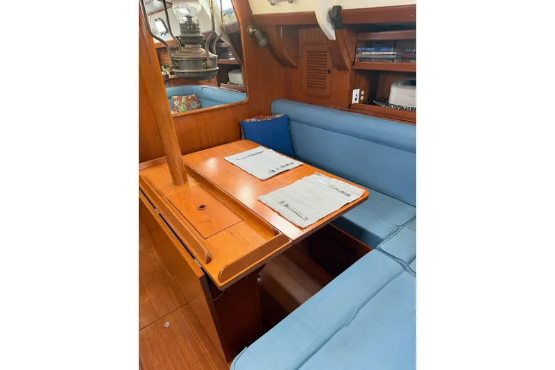 Slide: The Image of Interior of 1989 Tayana Vancouver 42 sailboat with wooden dining table and blue seating. - 24