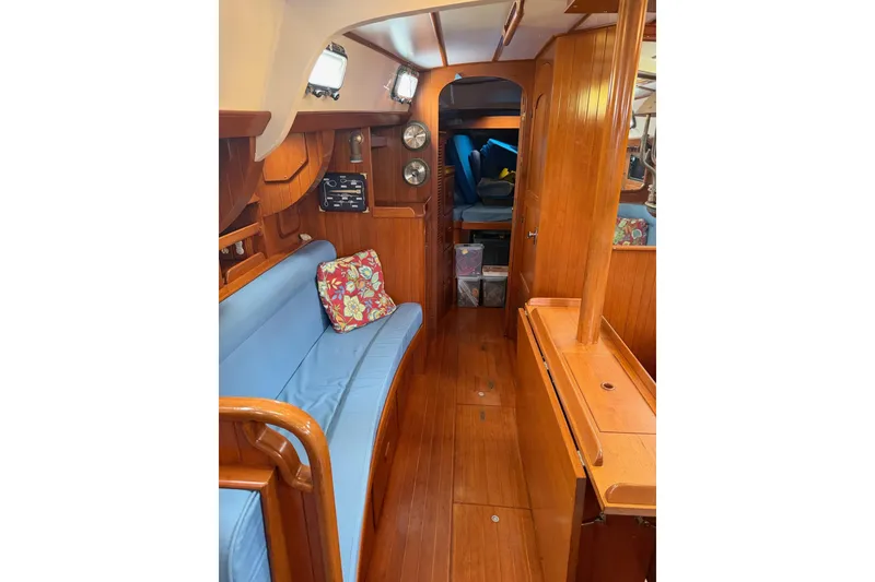 Slide: The Image of Interior of 1989 Tayana Vancouver 42 sailboat with wooden finish and blue seating. - 26