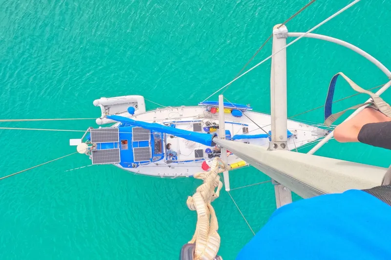 Slide: The Image of Aerial view of 1989 Tayana Vancouver 42 sailboat with solar panels on turquoise water. - 34